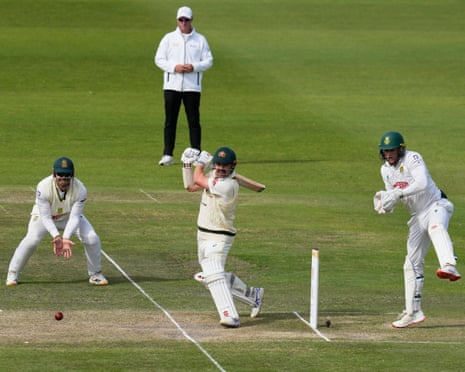 Travis Head plays a shot as South African fielders and an umpire watch closely