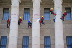 Members of Greenpeace climb the columns of the Finnish parliament in Helsinki during a climate change demonstration
