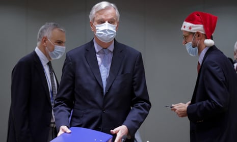 European Union chief negotiator Michel Barnier, centre, carries a binder of the Brexit trade deal during a meeting at the European Council building in Brussels.