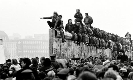 East and West German people celebrate the end of cold war on top of the Berlin Wall, 10 November 1989.