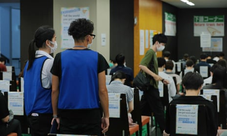 Staff at a Covid-19 vaccination centre at Tokyo look over a post-jab waiting room
