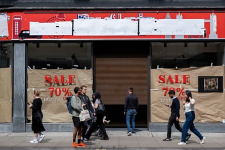 Shoppers walk past a closed-down store in Oxford Street, central London