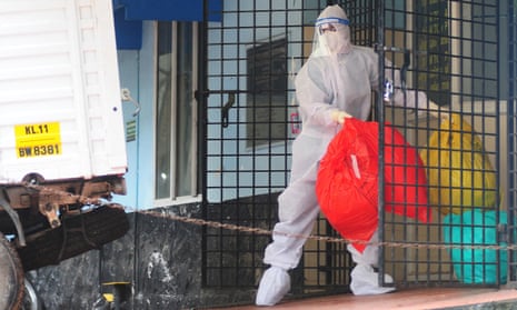 A health worker wearing protective gear disposes biohazard waste from a Nipah virus isolation centre at a government hospital in Kozikode