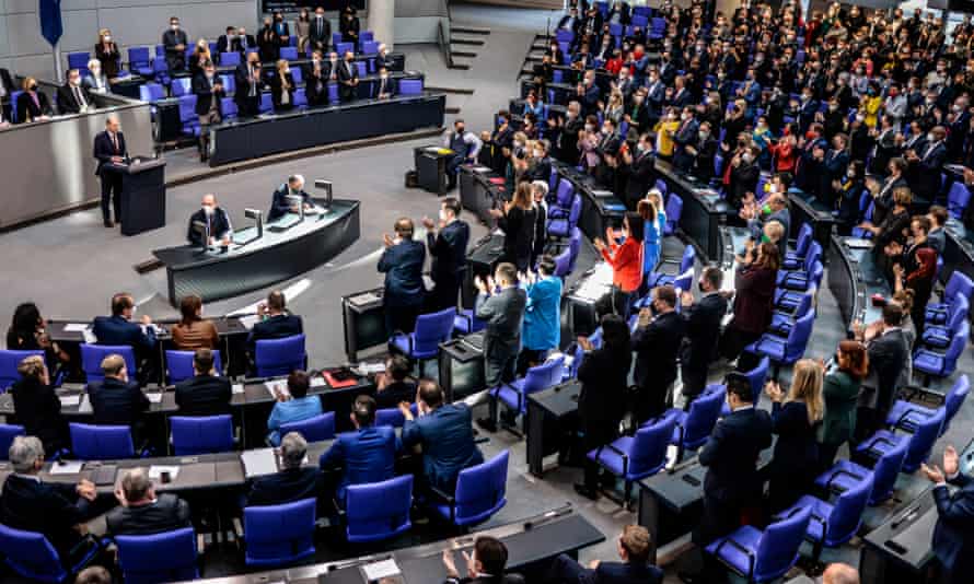 The German chancellor, Olaf Scholz, receives a standing ovation after a speech to the Bundestag