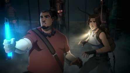 Jonah Maiava and Lara Croft hold torches in a dark chamber in the TV series Tomb Raider: The Legend of Lara Croft
