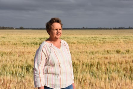 Liza Balmain stands in a field under a stormy sky