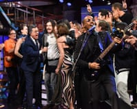 Stephen Colbert among a joyous crowd singing on stage