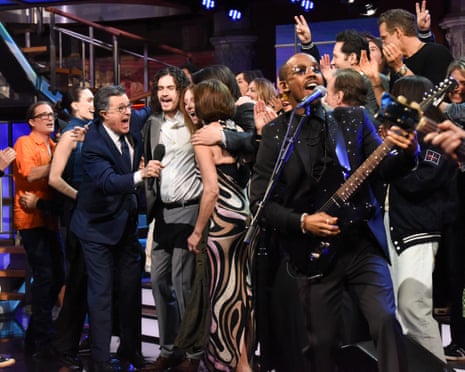 Stephen Colbert among a joyous crowd singing on stage
