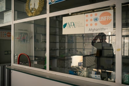 A glass partition in front of a pharmacy, which is closed and dark.