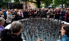 People stand next to the memorial ‘Iron Roses’ outside the cathedral in Oslo on 28 September 2019 to commemorate the 77 victims of the attacks by Anders Behring Breivik. 