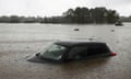 A partially submerged car abandoned in flood waters in Windsor, on Sydney's fringe, on Monday