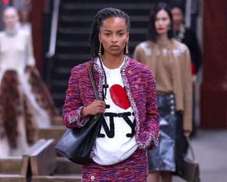 A model wearing a tweed skirt suit with a T-shirt underneath