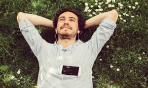 Young man relaxing in the grass and enjoying the music