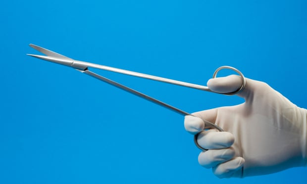 Medical scissors in gloved hand