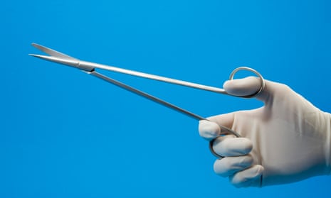 gloved hand holds forceps