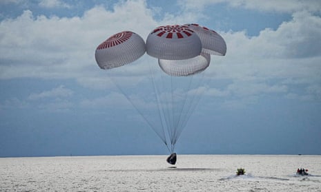 In this image taken provided by SpaceX, a capsule carrying four people parachutes into the Atlantic Ocean off the Florida coast, Saturday, Sept. 18, 2021. The all-amateur crew was the first to circle the world without a professional astronaut.  (SpaceX via AP)