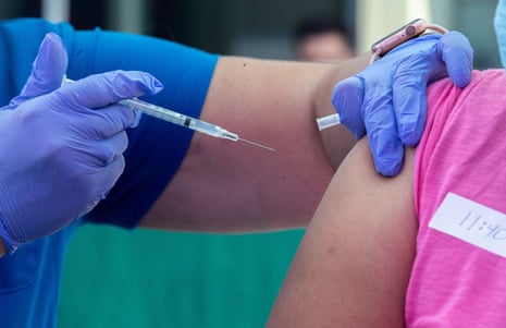 RN Amy Berecz-Ortega, left, inoculates a woman at a Covid-19 vaccine event in Los Angeles.