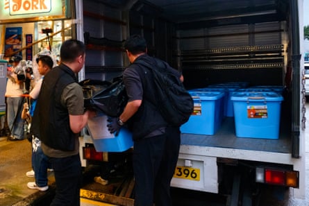 Police officers load confiscated items from independent bookstore Have A Nice Stay.