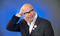 Harry Hill in a shirt and suit jacket with his hand on his head