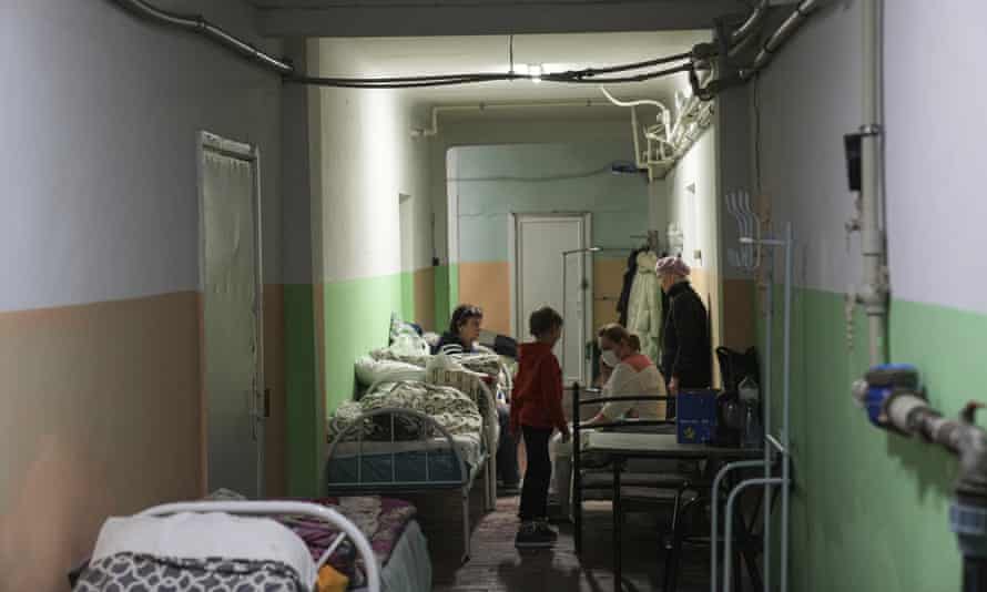 Women and children sit in the basement of a maternity hospital converted into a medical ward and used as a bomb shelter in Mariupol, Ukraine