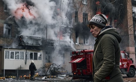 A local resident walks past her burning house after Russian shelling in Bakhmut, Donetsk region.