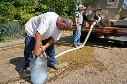 People fill up a five-gallon jug from a water tanker in Jackson on 31 August.