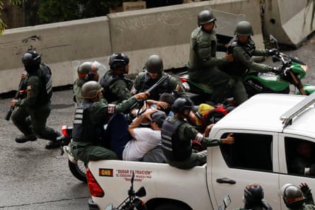 Members of the Bolivarian national guard detain demonstrators in Caracas on Tuesday.