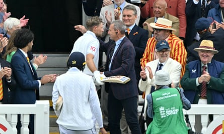 Joe Root is embraced by his father Matt as he walks up the pavilion steps after making his second hundred in the match