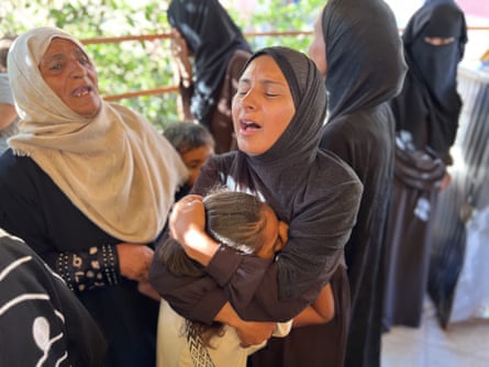 Women weeping and hugging chiild