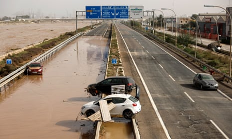 Damaged vehicles lie along a motorway in Valencia.
