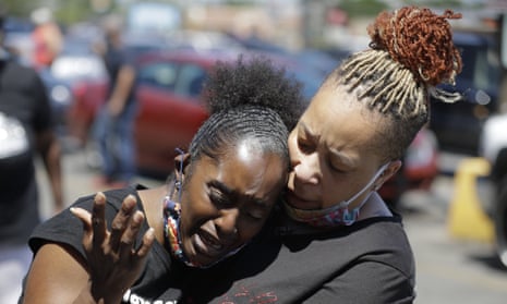 Two women pray on Tuesday in Louisville, Kentucky, near the intersection where David McAtee was killed.