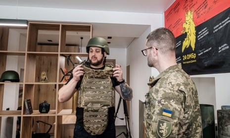 A man tries on a helmet and a body armour during the opening of the recruitment centre in Lviv.