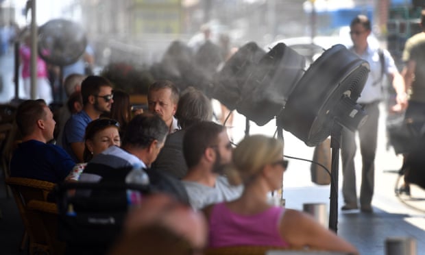 Fans spray water on customers on the terrace of a bar in Madrid