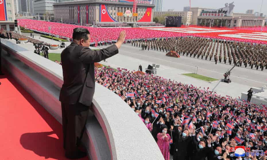 North Korean leader Kim Jong-un waves to crowds during the parade marking the birthday of his grandfather.
