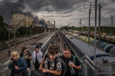 People walk up a footbridge towards the camera after leaving trains
