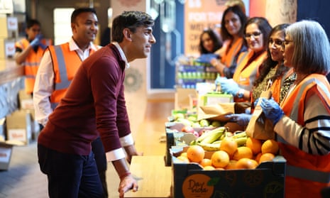 Rishi Sunak meets volunteers preparing food packages during a visit to OmNom, a restaurant and community centre in north London
