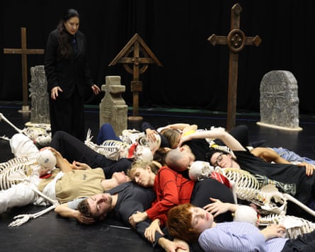 Abramović stands above her cast who lie on the floor with skeletons on top of them.