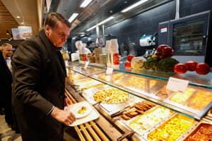 Handout picture released by the Brazilian presidency showing Brazilian President Jair Bolsonaro serving his lunch at a Migros supermarket restaurant in Davos, Switzerland, after speaking at the World Economic Forum on January 22, 2019.