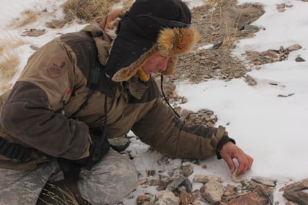 The lead tracker and wolf hunter Valery Orgunov examines potential snow leopard excrement.