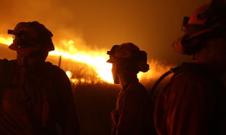 Incarcerated firefighters stand guard as flames from the Butte fire approach a containment line near San Andreas, California, in 2015.