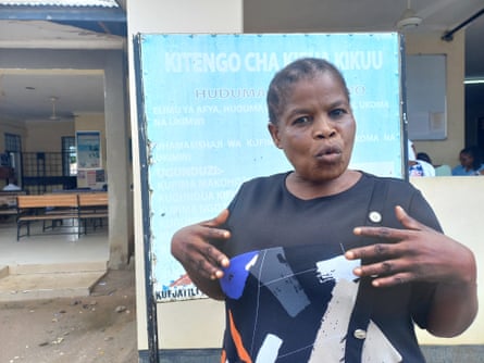 An African woman speaking outside a community clinic