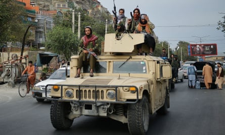Taliban fighters atop a Humvee vehicle celebrate the departure of US troops this week.
