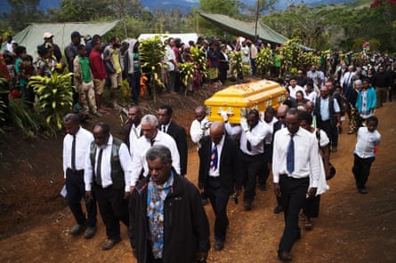 Mourners watch as the coffin followed by the Leahy family is carried toward the grave site next to Joe Leahy’s home at Kilima