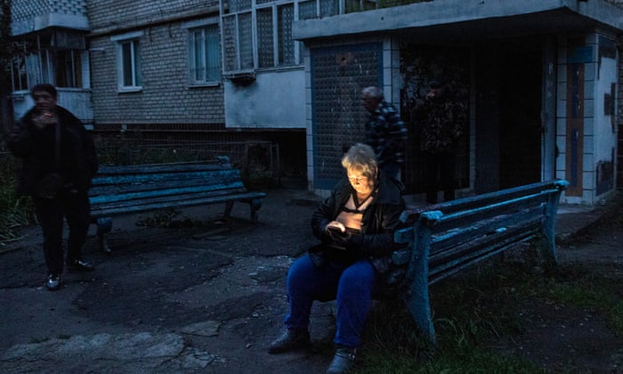 A woman checks her mobile phone connection as communications are still cut in Izium, Ukraine.