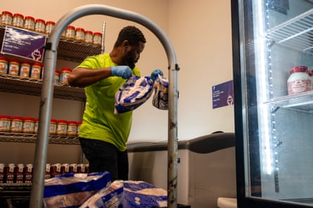 A man unloads bags of frozen chicken in a pantry