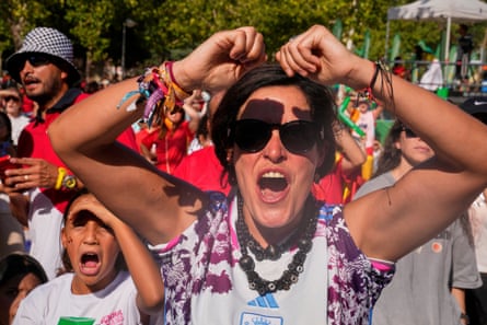 People watch the Women’s Euro 2025 final soccer match between England and Spain on a big screen in a park in Madrid