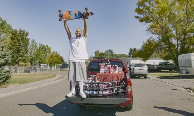 Nathan Apodaca holds his skateboard while standing in the back of a truck containing Ocean Spray products.