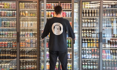 Homem olhando para a geladeira de cerveja na Clapton Craft