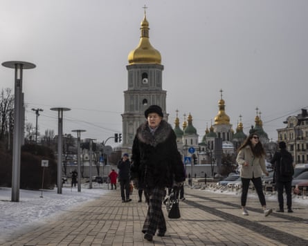 People walking along a path with the golden dome of St Sophia’s Cathedral in the background