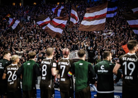 St Pauli players acknowledge the fans as they sing and wave flags